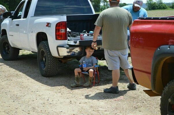 SHADE FOUND - This youngster found a shady spot under the tailgate of a truck after a morning of fishing at the Hickman Recreation Tourism Convention Commission's Fishing Rodeo held June 5, at Hamby Pond below Hickman. (Photo by Barbara Atwill)