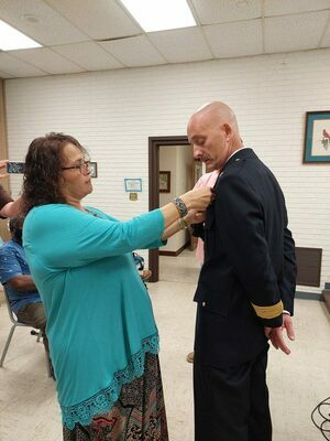 PINNING CEREMONY - Frankie Martin places the fire chief pin on her husband, Jeremy Martin, Fulton's new Fire Chief at the Fulton City Commission on July 25. (Photo by Barbara Atwill)