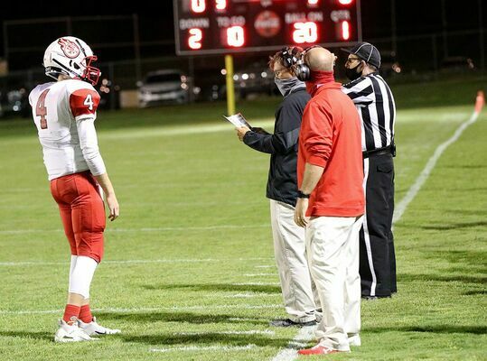 PLAY CALL – Red Devils head coach Eric Knott (center) looks over his play sheet, as quarterback Bryce Harper waits for the call. South Fulton posted their first win of the year Friday night at Fulton County, beating the Pilots 6-0 in overtime. (Photo by Charles Choate)