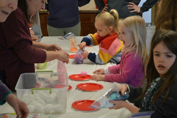 DYING EGGS - Children dyed boiled eggs at one of the activities set up for the children at the Cayce United Methodist Church's annual Easter egg Hunt on April 9. Gel food coloring was placed in a bag with rice, then the egg was put inside and sealed. The children rolled, shook, and bounced until the egg reached the color they wanted. (Photo by Barbara Atwill)
